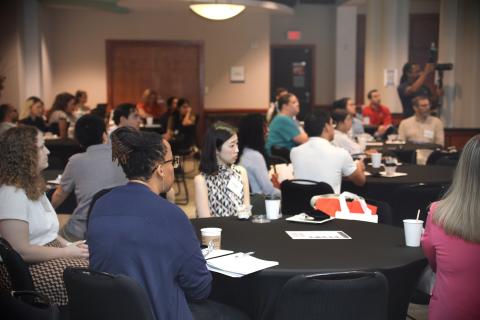 postdocs sitting at a round table listening to a speaker