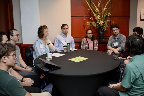 several postdocs sit around a table talking