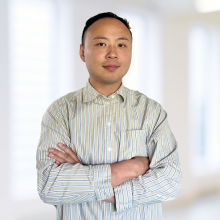 A person stands in front of a white background.