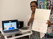 Lydia Contreras poses with Dale Forrister's teaching certificate as Dale Forrister poses via Zoom on a laptop screen.