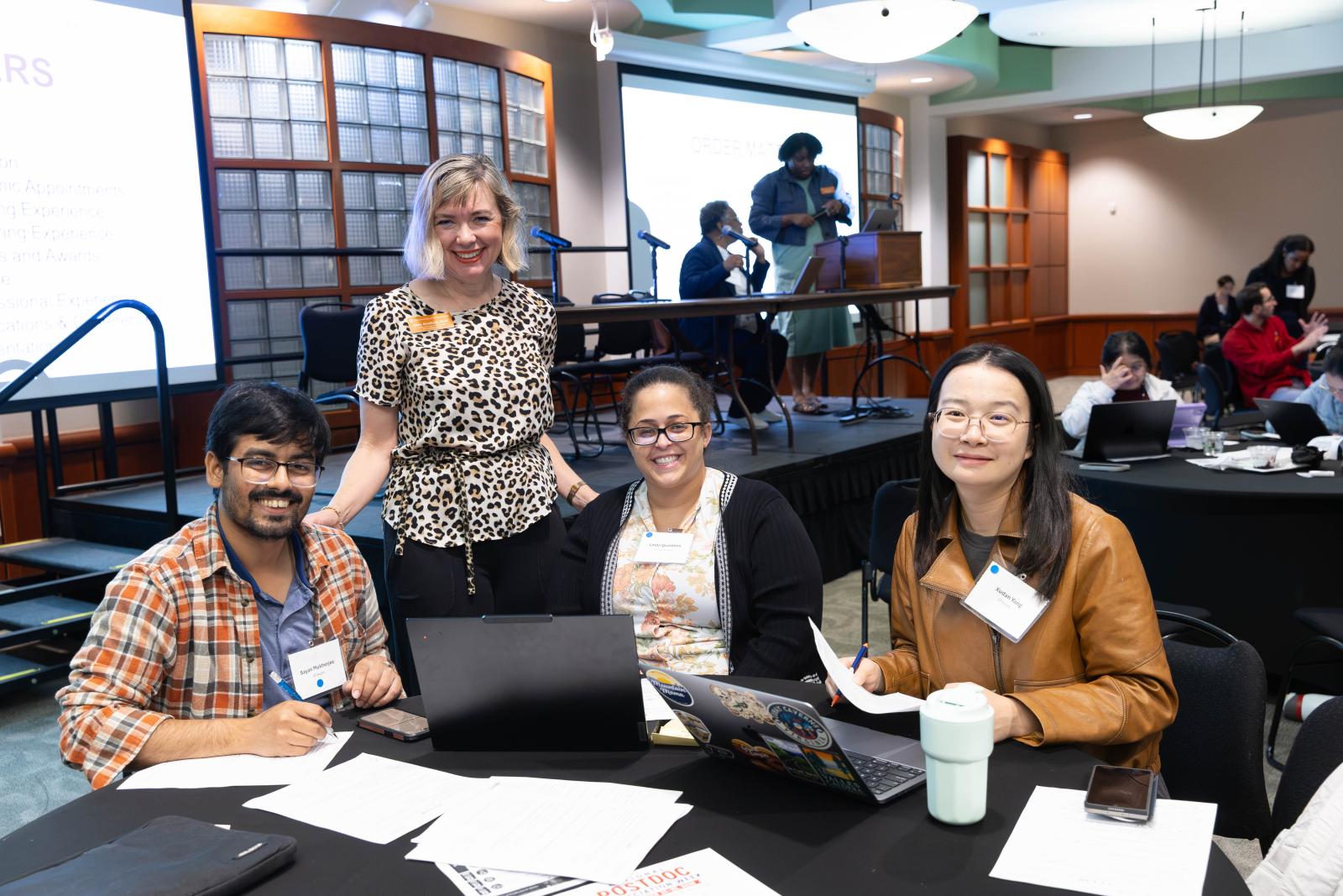 three postdocs and a staff member smile