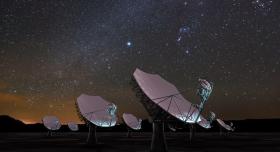 Satellite dishes under a night sky.
