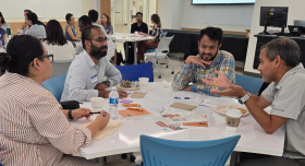 A group of fellows sit around a table for an activity.