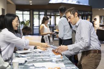 Postdoc helping a colleague check in for conference