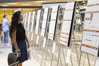 Postdoc reading posters from a poster session