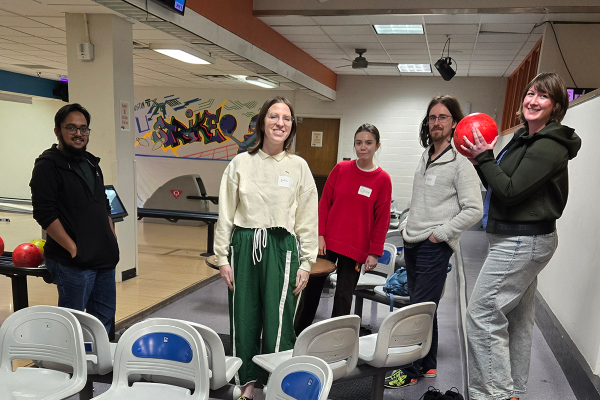 five postdocs in a bowling alley, one holds a bowling ball