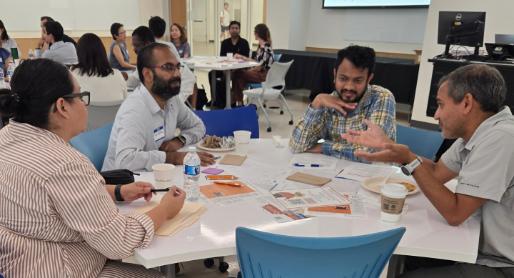 A group of fellows sit around a table for an activity.